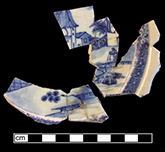 Chinese porcelain saucer painted underglaze blue in pavilion landscape pattern.  Hex cell diaper rim on cavetto. Believed to be either Second (c. 1750-1780) or Third Period (c. 1780-1820) Pavilion Landscape pattern as discussed in Madsen and White (2011:81-85).